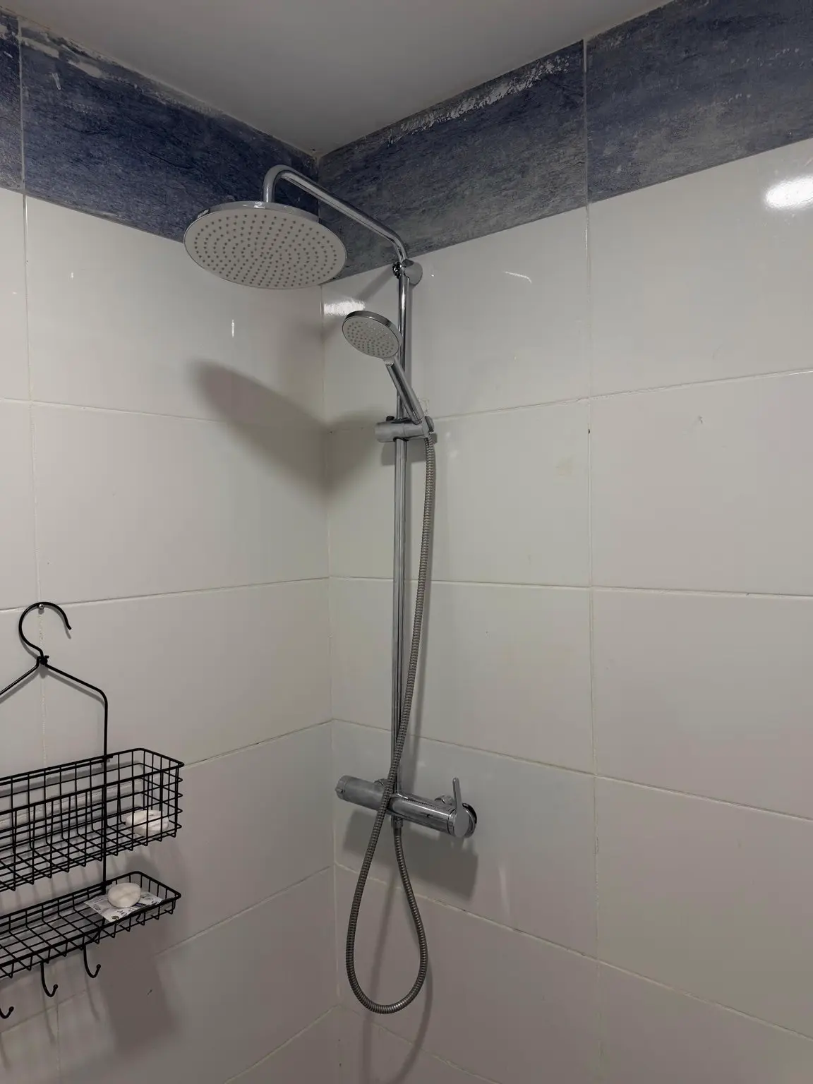Zona de duche depois da intervenção, com coluna e chuveiro superior