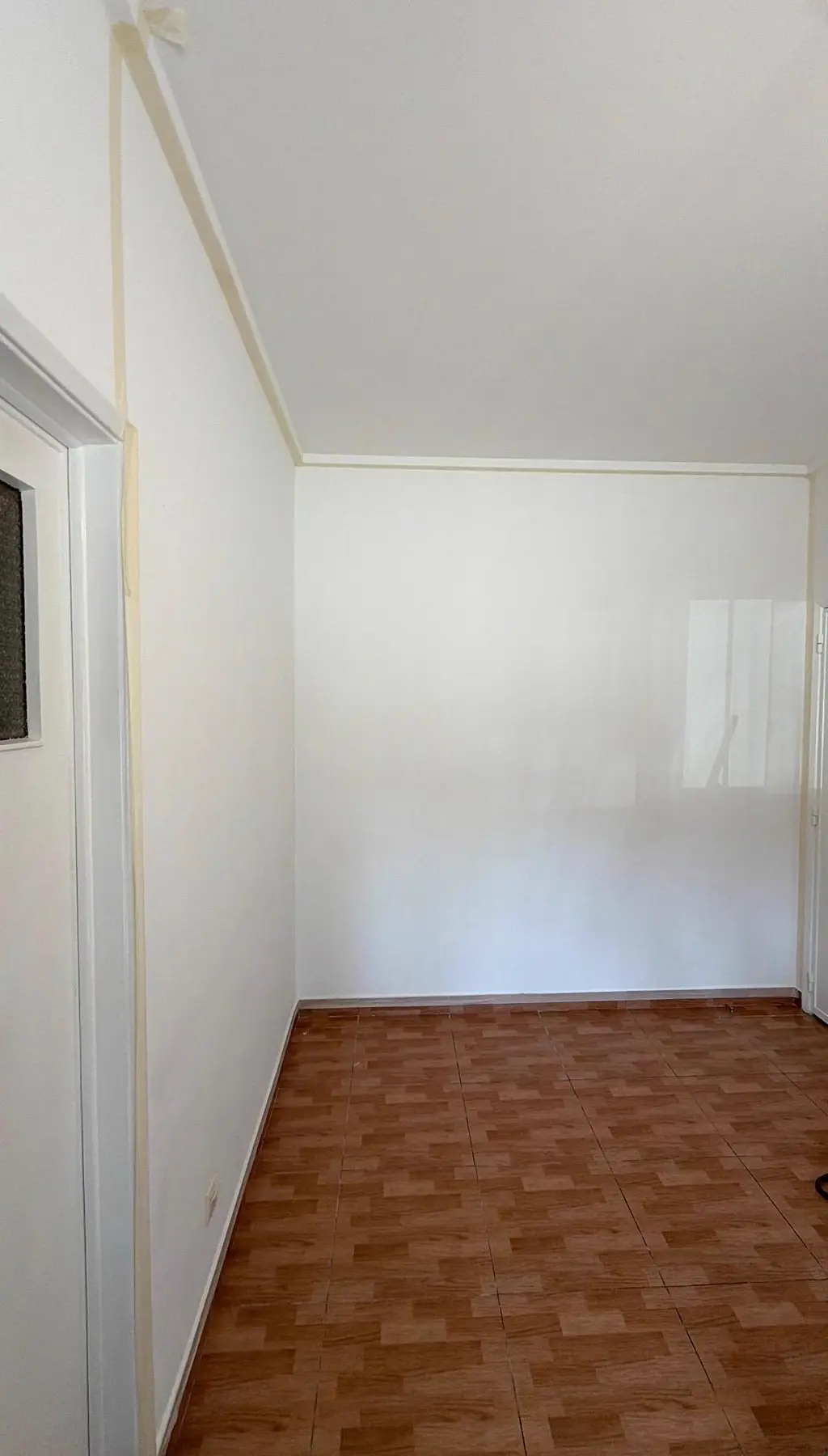Espaço vazio antes da intervenção, com parede livre e pavimento existente