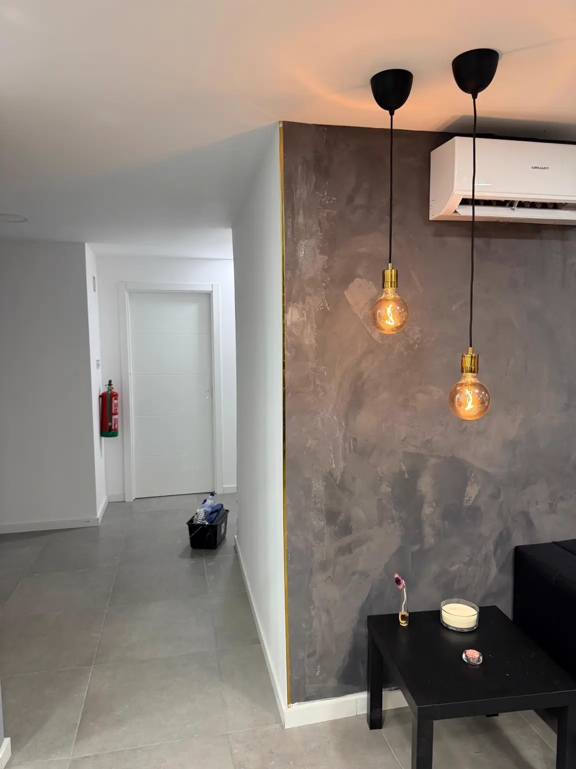 Interior remodelado pela Lob Marks com parede decorativa e iluminação suspensa